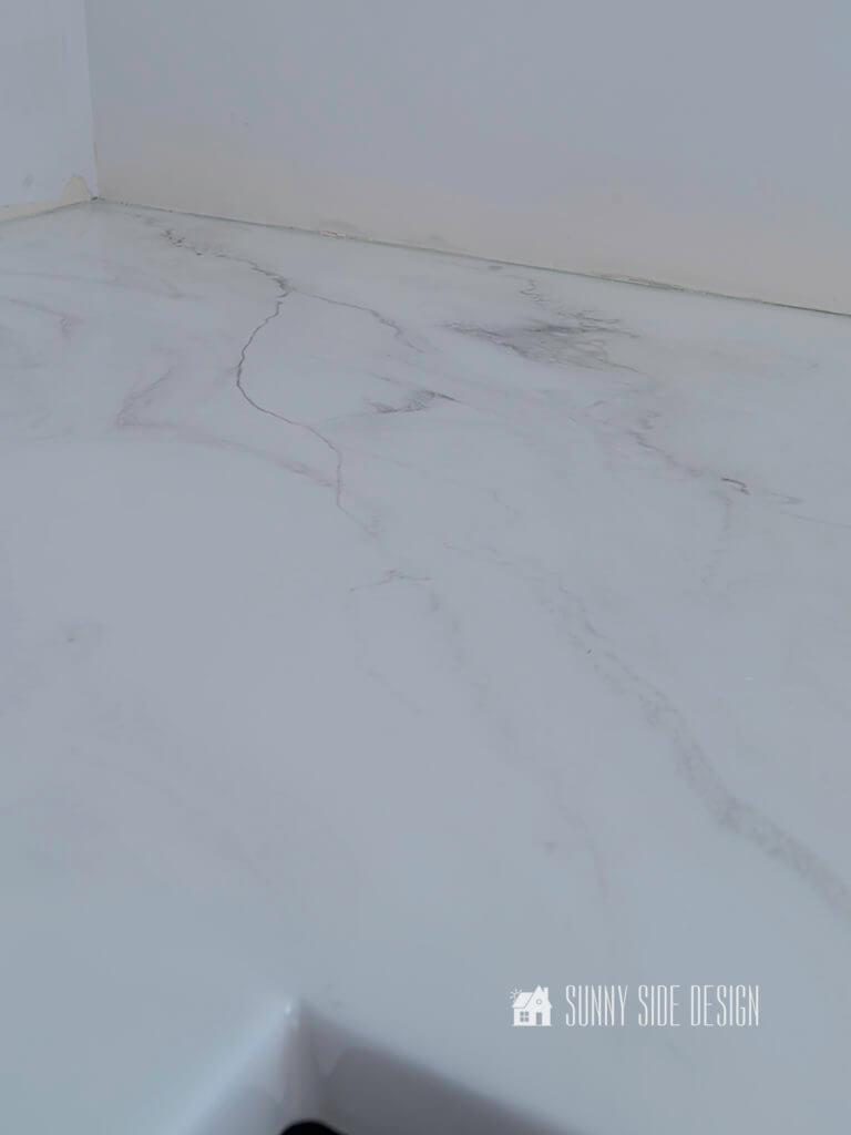 Epoxy countertop with a carrara marble look, white with grey veining.