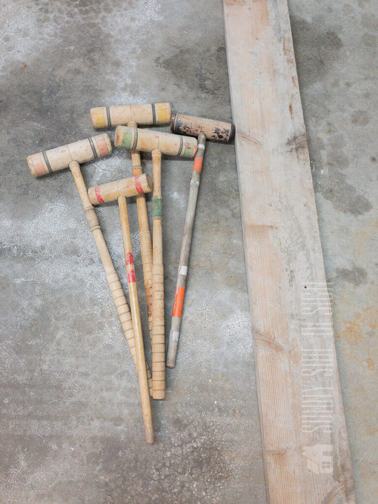 Thrift store croquet mallets and an old board to be used to make a blanket ladder