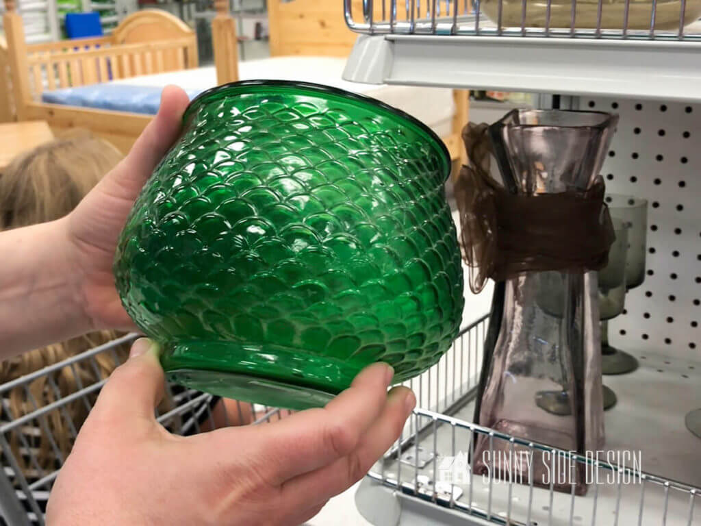 Woman's hands holding a green glass thrift store pot