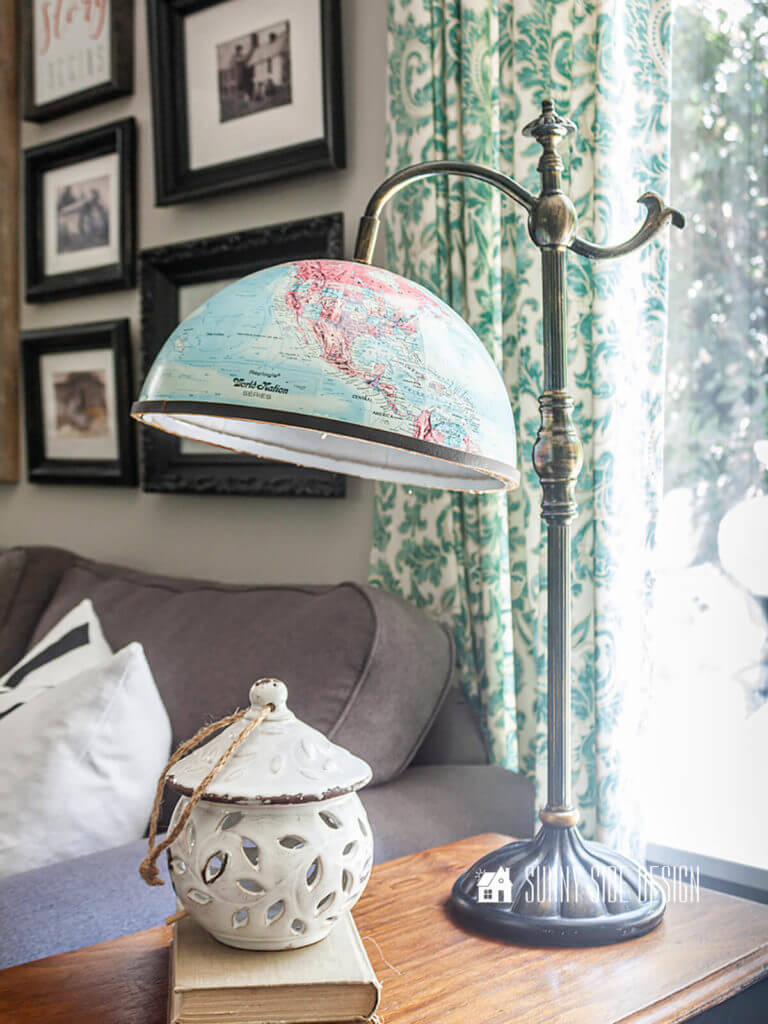 Flea market flip ideas, thrift store lamp and globe and upcycled into a fun table lamp, setting on a vintage sewing table with stacked books and a birdhouse