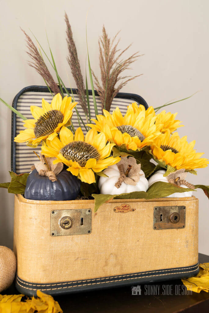 Flea market flip ideas, vintage train case is upcycled into a container for a sunflower floral arrangement