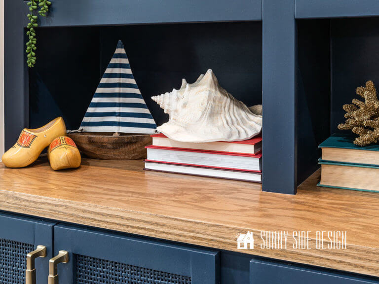 How to apply water based stain - finished stained wood for built in entertainment center, decorated with sailboat, books, shell, and wood shoes.