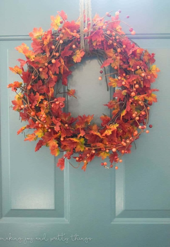 Fall color leaf wreath with bittersweet vine on a light blue door.