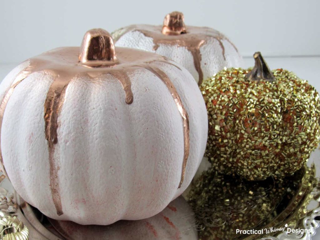 White Painted dollar store pumpkins with dripped copper colored paint.