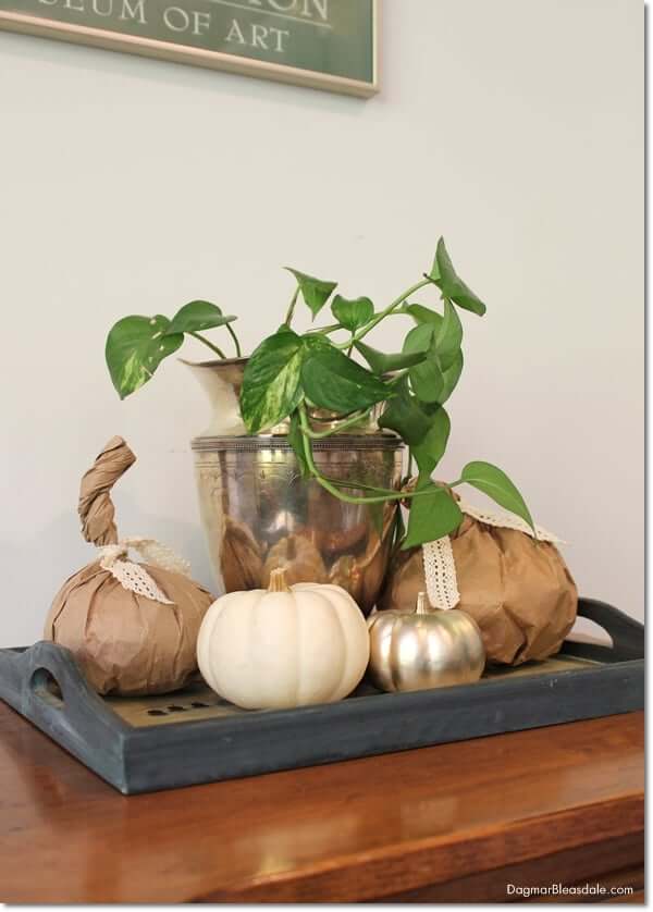 DIY Fall Decor ideas, diy paper bag pumpkins styles on a tray with a green plant in a silver pitcher and white pumpkins.