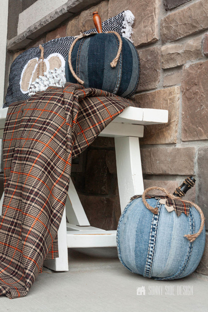DIY Fall Decor ideas, DIY pumpkin with old jeans and a trick or treat bucket. Styled on a white farmhouse bench with a brown and orange throw.