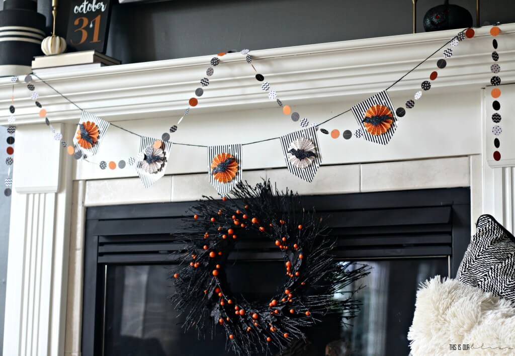 Easy Halloween decor ideas for your home. Mangle is draped with a paper circle garland and a black and white and orange bunting. A black twig wreath is also placed in front of the fireplace.