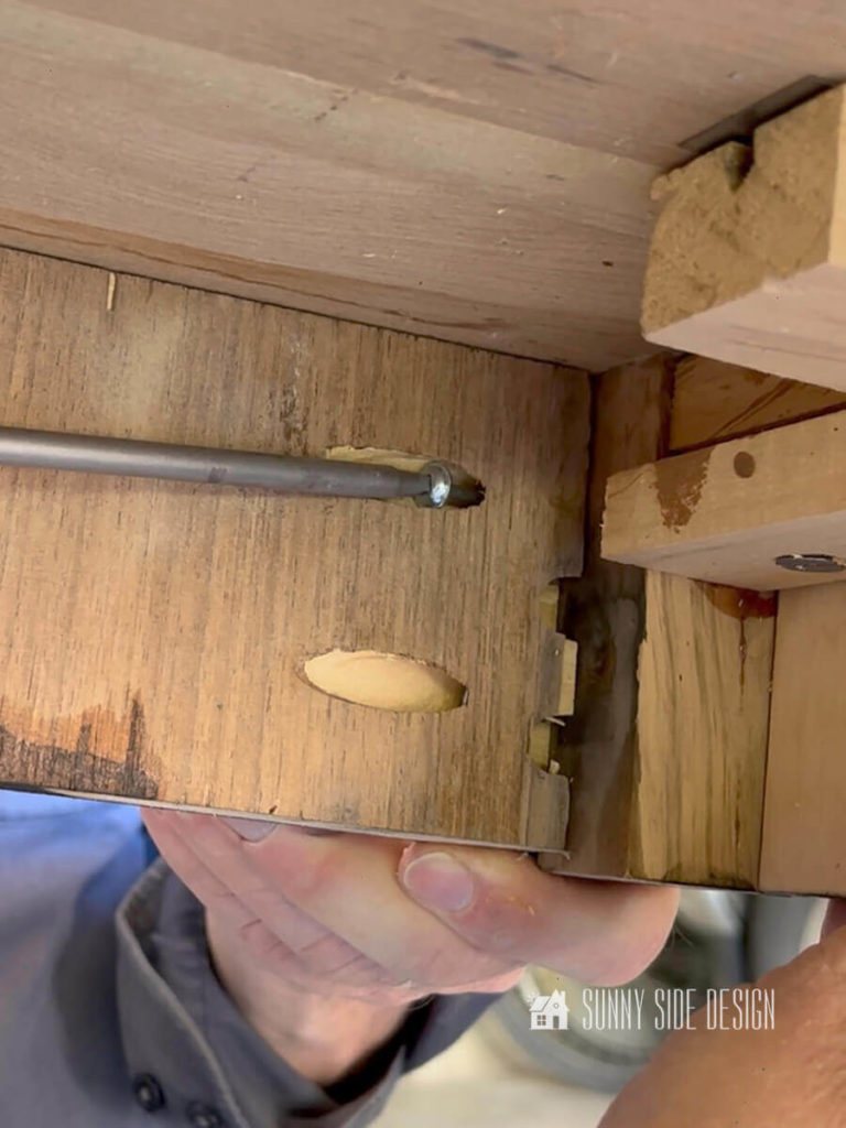 Pocket screw inserted into pocket hole to attach the faux drawer front.