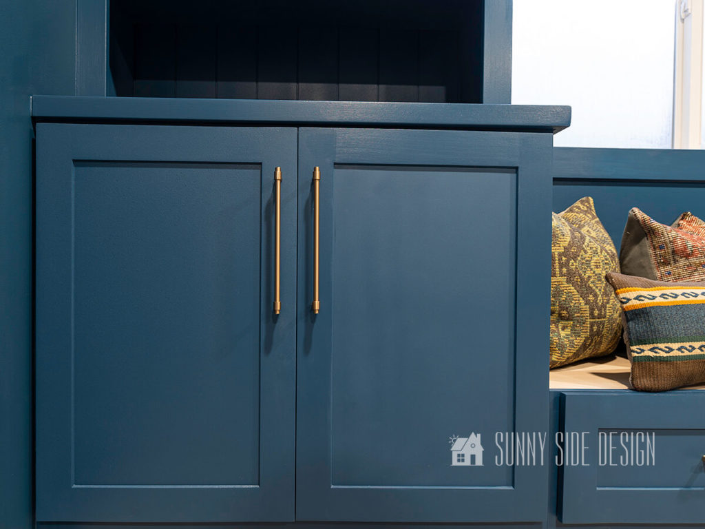Finished Shaker doors painted dark blue with champagne gold pulls on an office built in bookcase.