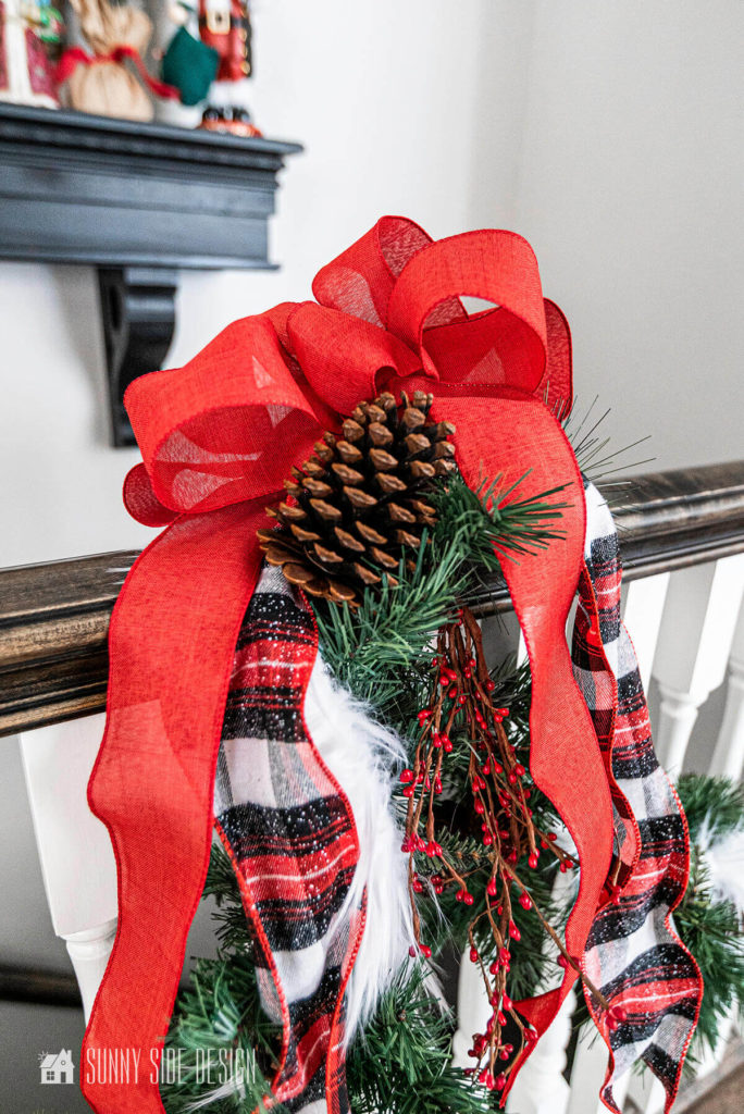 Simplify Christmas decorating, garland is embellised with red flannel ribbon and a red berry pick