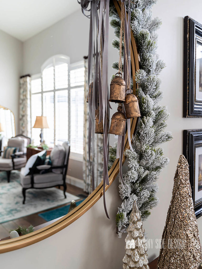 DIY Christmas bells hung on a round gold framed mirror.