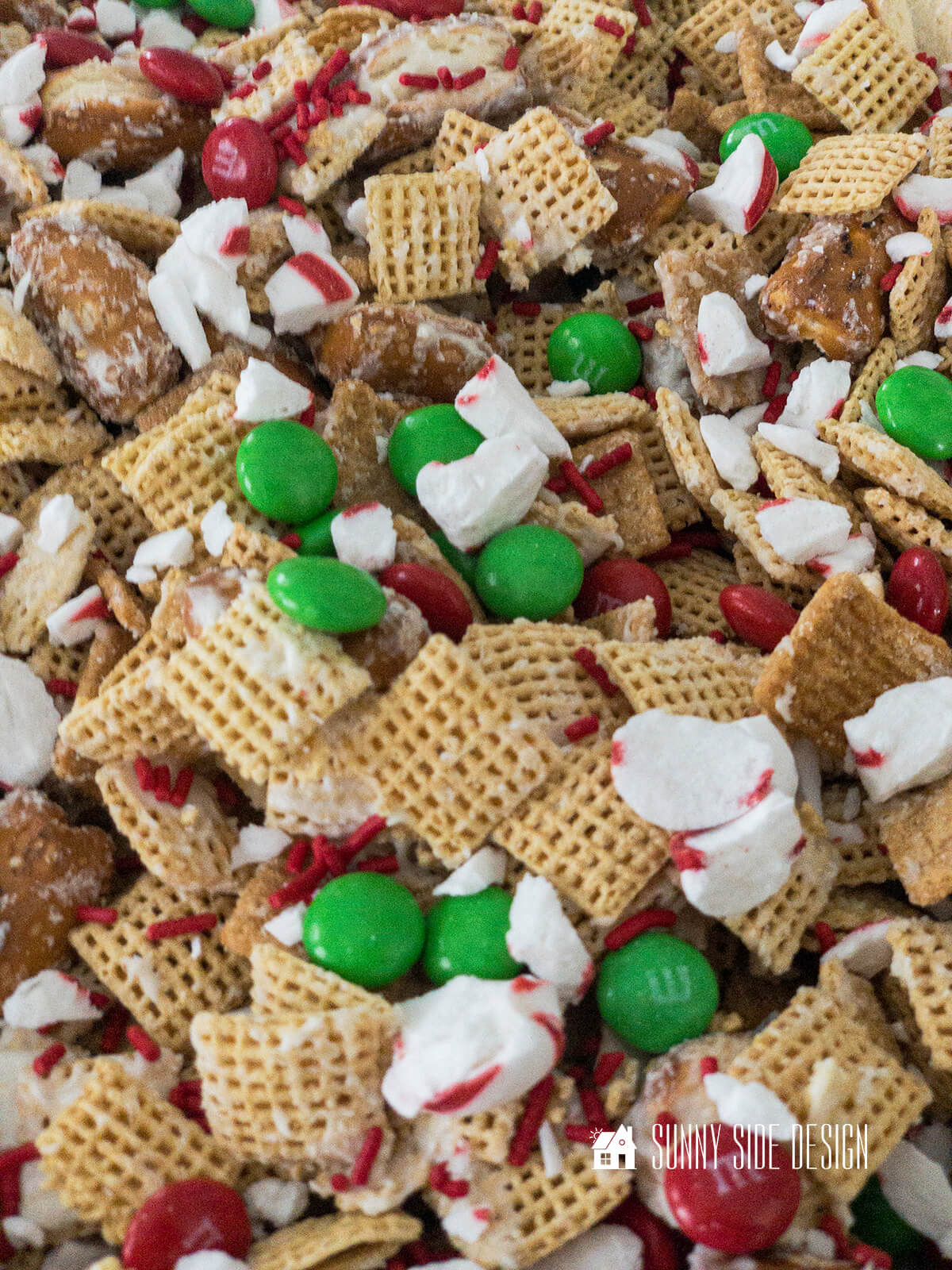 Festive Gift Idea for Neighbors, sweet and salty Christmas Chex mix with red and green M&M candy, peppermint candy and red candy sprinkles.