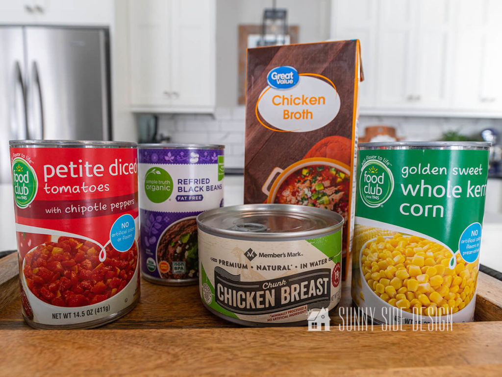 Ingredients for our easy and hearty soup recipe, canned tomatoes with chipotle peppers, can refried beans, chicken broth, canned chicken breast and canned corn.