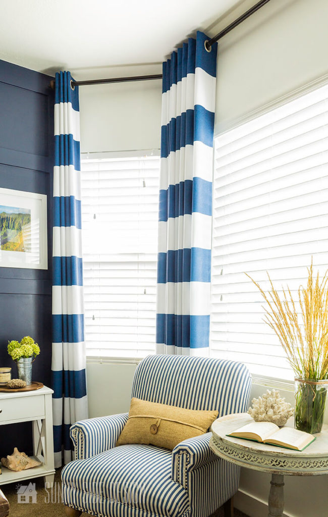 Window treatment ideas for Bay Window, striped blue and white ready made curtain panels in a bay window.