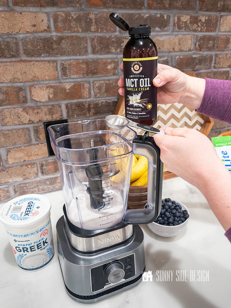 MCT oil is added to the healthy smoothie in a blender.