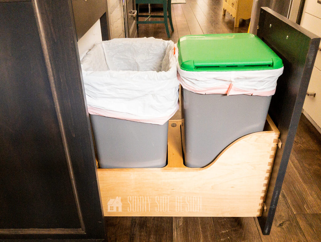 Add a pullout recycle and trash storage in a cabinet.