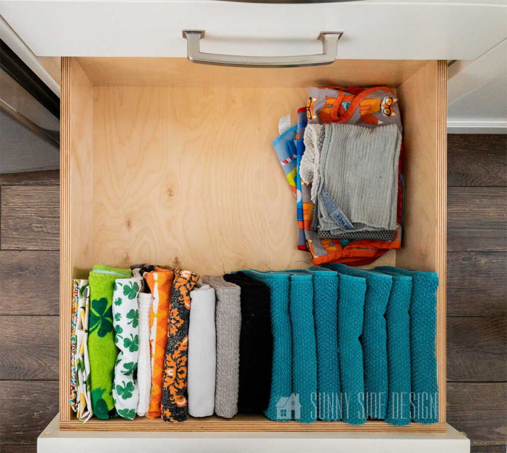 Small Kitchen Organization ideas, store towels and dish cloths vertically for more storage space.