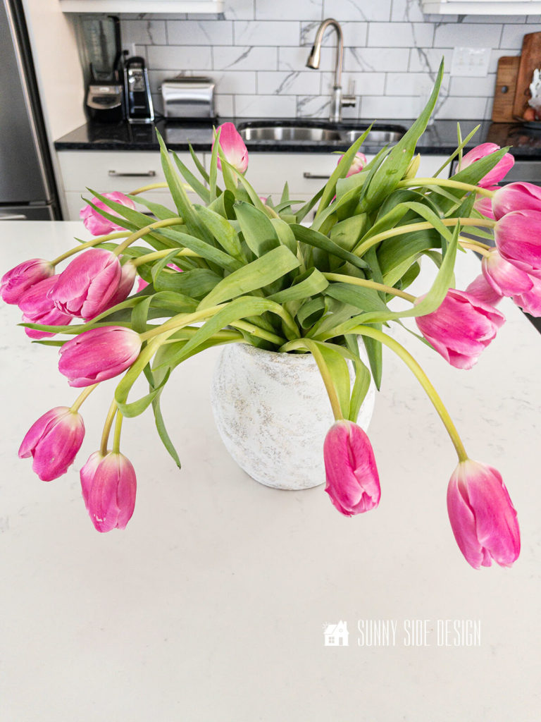 Pink Tulips are drooping in a vase.