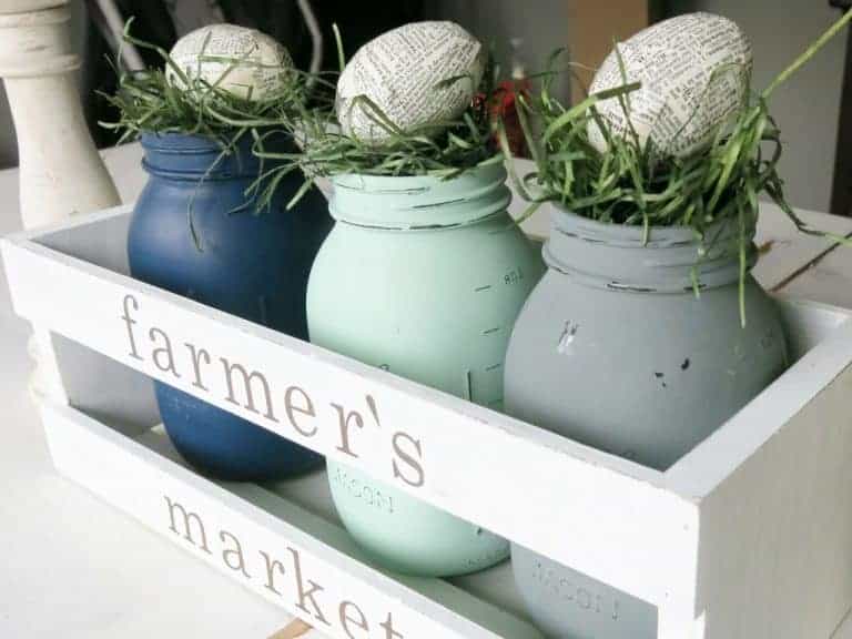 Spring table centerpiece, blue, green and grey painted mason jars filled with Easter grass and a book page Easter egg, Fun Farmhouse style Easter centerpiece.