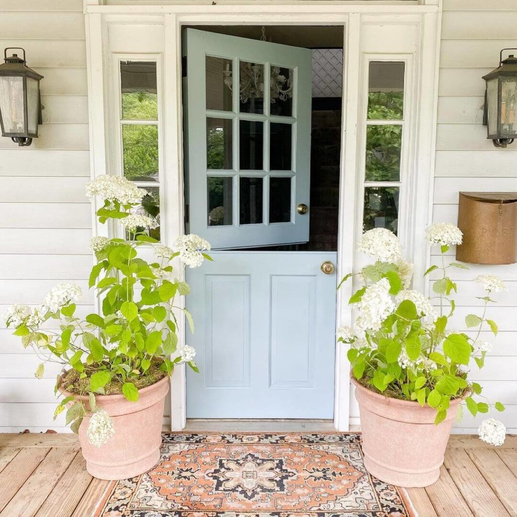 For a punch, think large pots and potted flowers. Pots frame the front door and welcome guests.