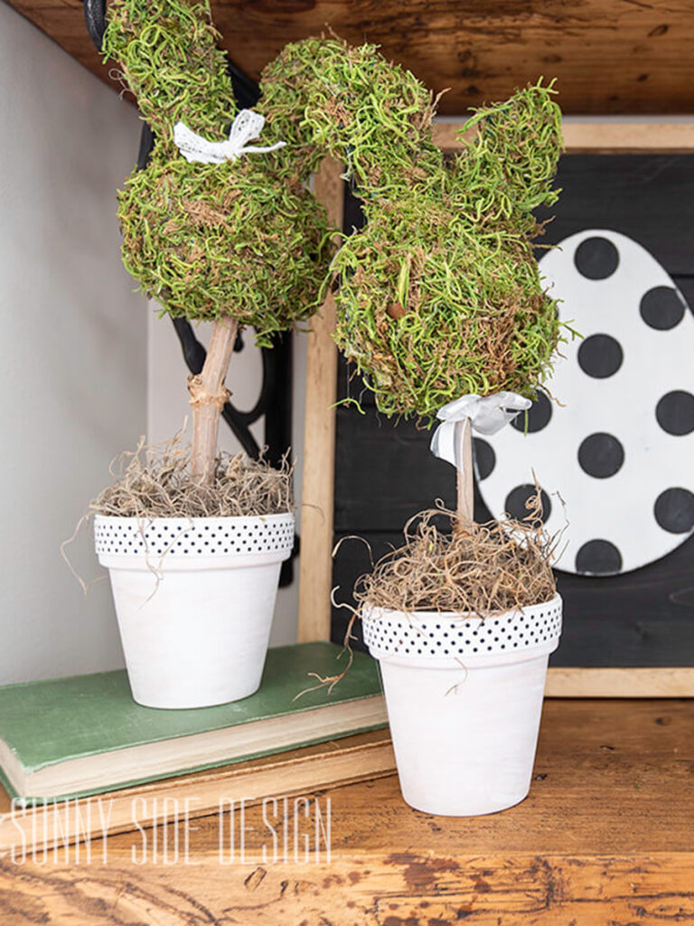 Moss bunny topiary Easter Decorations styled on a shelf.