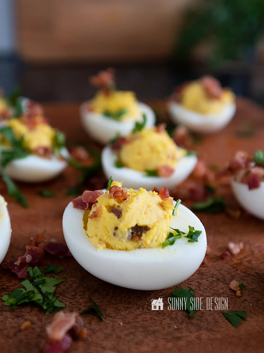 Looking for a classic recipe that will impress your guests at your next holiday gathering? This is it! The best deviled eggs recipe with a few simple ingredients plus a secret spice that takes them over the top. And don't forget the bacon! #classicdeviledeggs #bestdeviledeggsrecipe #deviledeggswithbacon