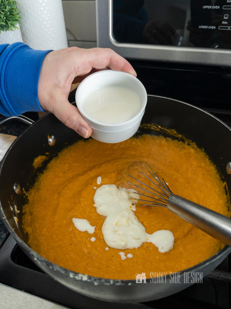 Add sour cream and milk to the butternut squash mixture in a heavy pan on the stovetop.