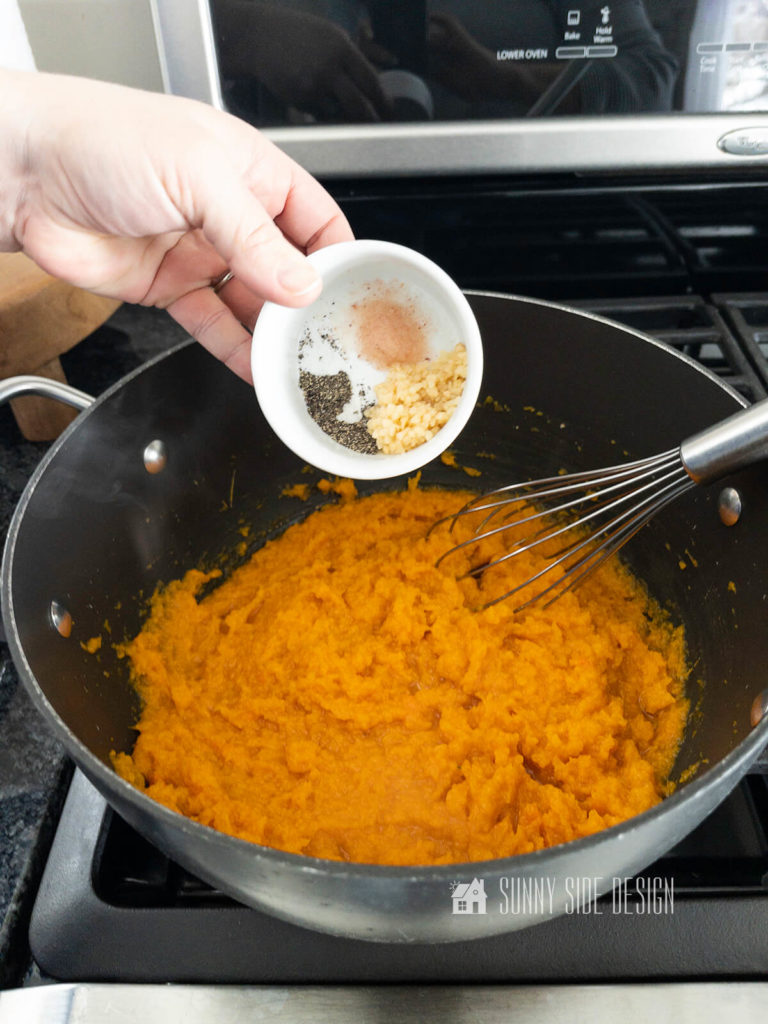 Add garlic, salt and pepper to the mashed butternut squash in a large pan, heat until garlic is cooked.