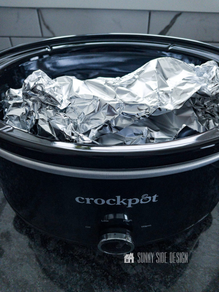 Place butternut squash wrapped in foil into a slow cooker and cook until tender.