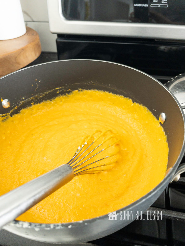 Stir healthy mac and cheese sauce with a whisk until smooth on the stovetop.