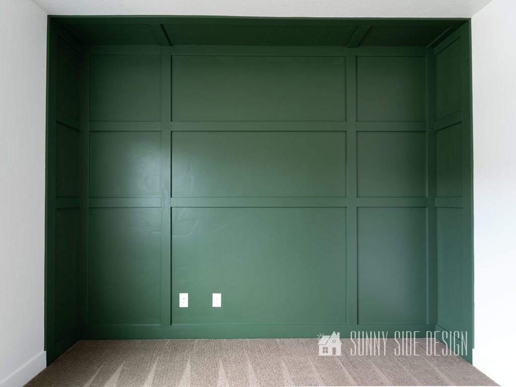 Completed DIY board and batten wall painted forest green.