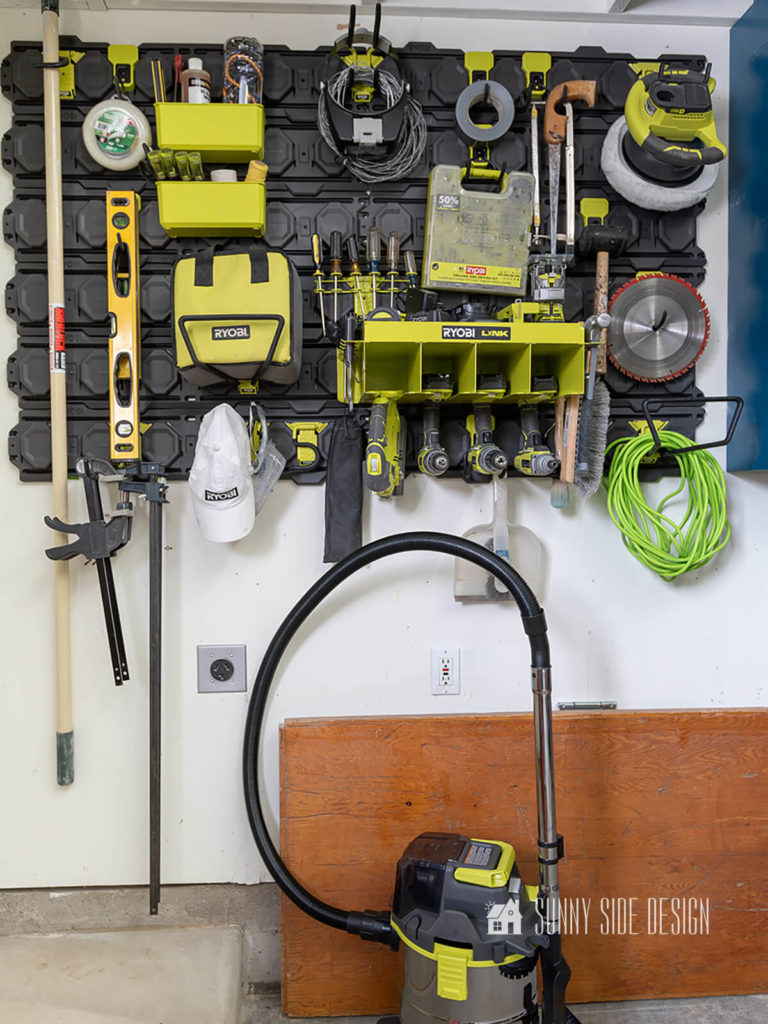 Garage wall storage is organized with tools, with shop vacuum.