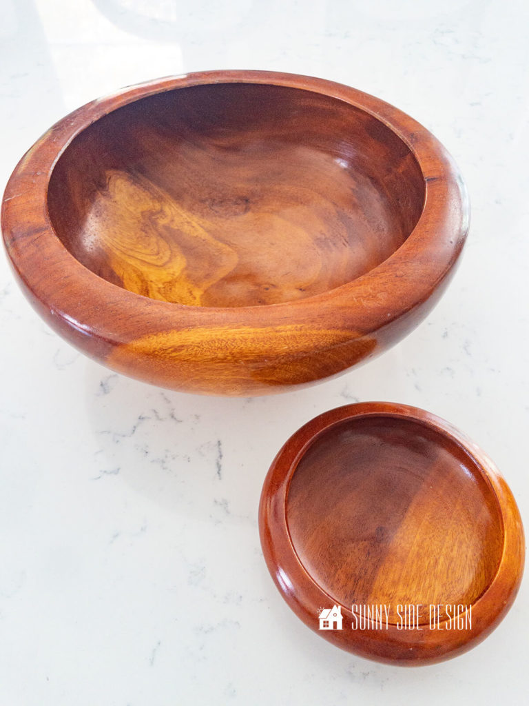 Two wood bowls, one large and one small on a white countertop.