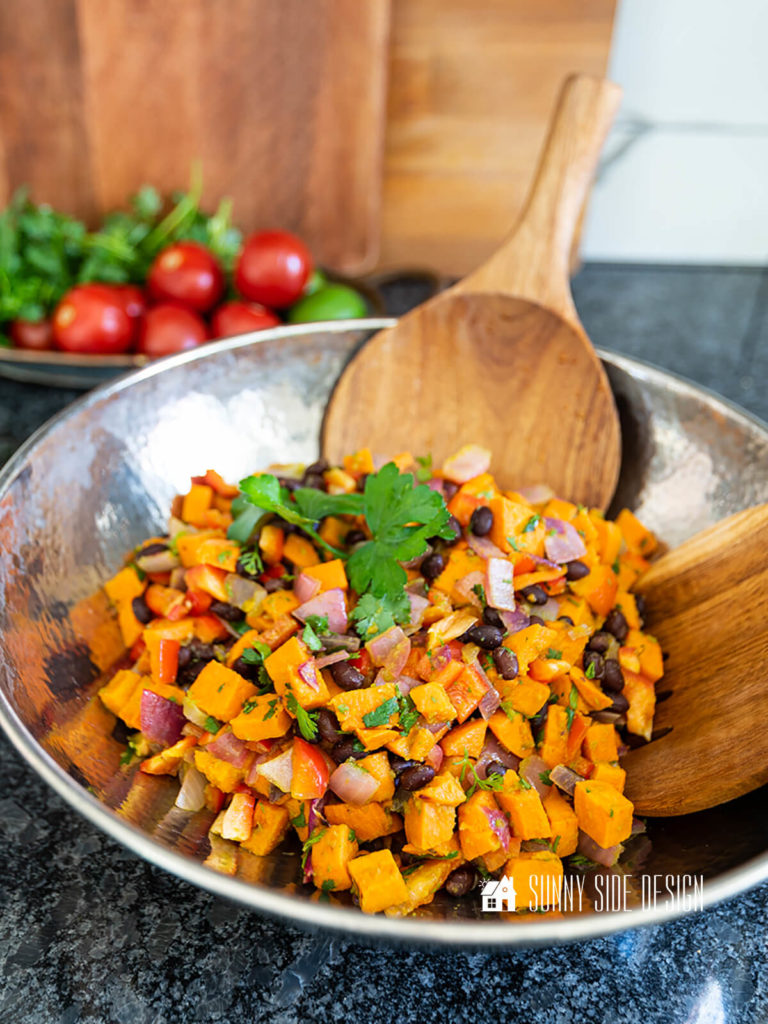 Easy roasted sweet potato salad in a silver serving dish with wooden serving spoons.