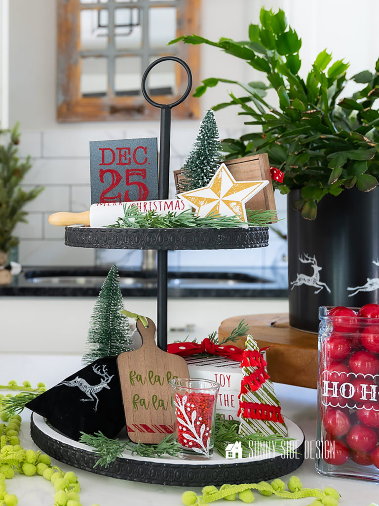 Christmas tiered tray decor, rolling pin, cutting board, book stack, black velvet back, tree, star, bottle brush tree, mini chalkboard. on a black and white tiered tray.