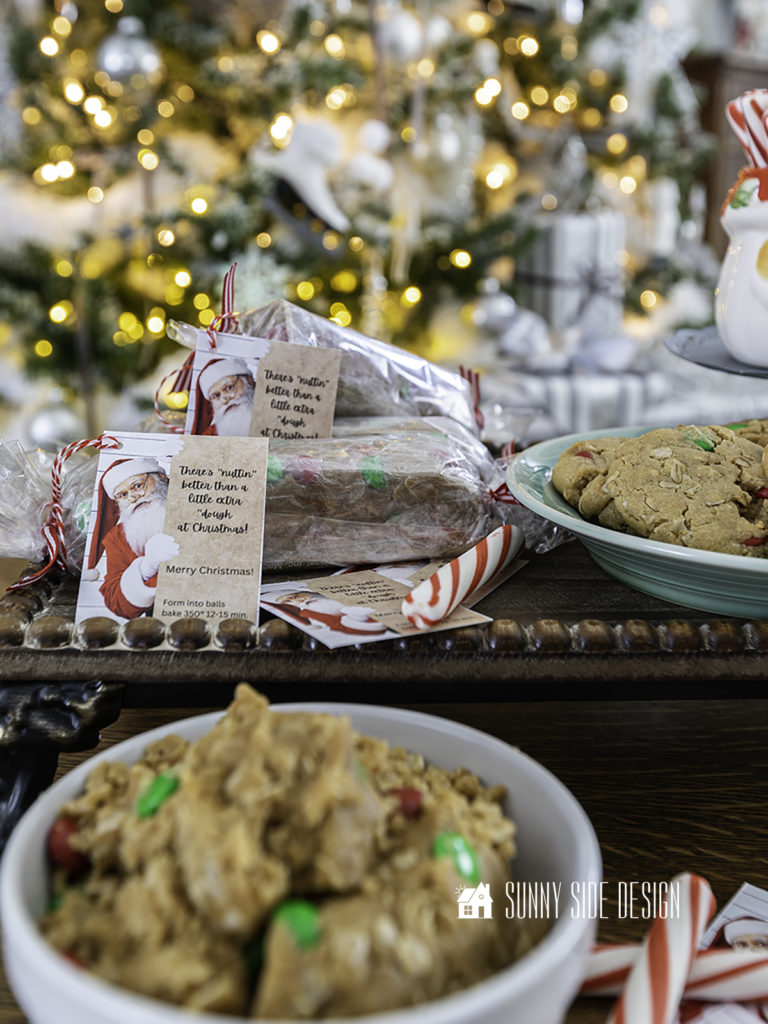 Peanut butter oatmeal cookies rolled into a dough log and wrapped in cellophane and tied with red bakers twine with a Christmas gift tag that reads: "There's nuttin' better than a little extra dough at Christmas!"