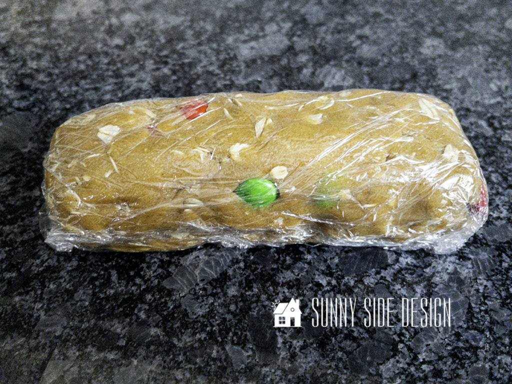 Peanut butter oatmeal cookie dough rolled into a log shape and wrapped with plastic wrap.