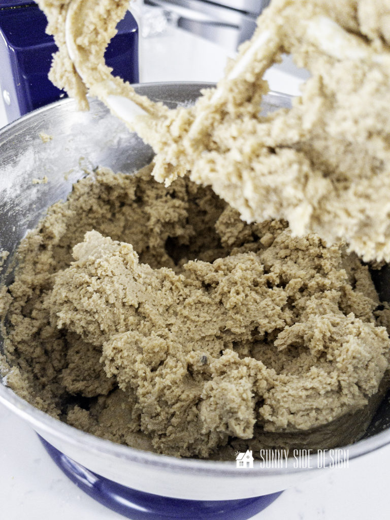 Peanut butter oatmeal cookie dough in bowl of stand mixer.