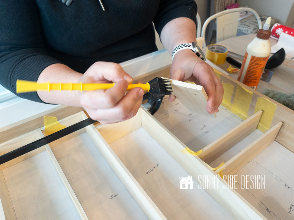 Apply glue to one end of wood drawer divider.