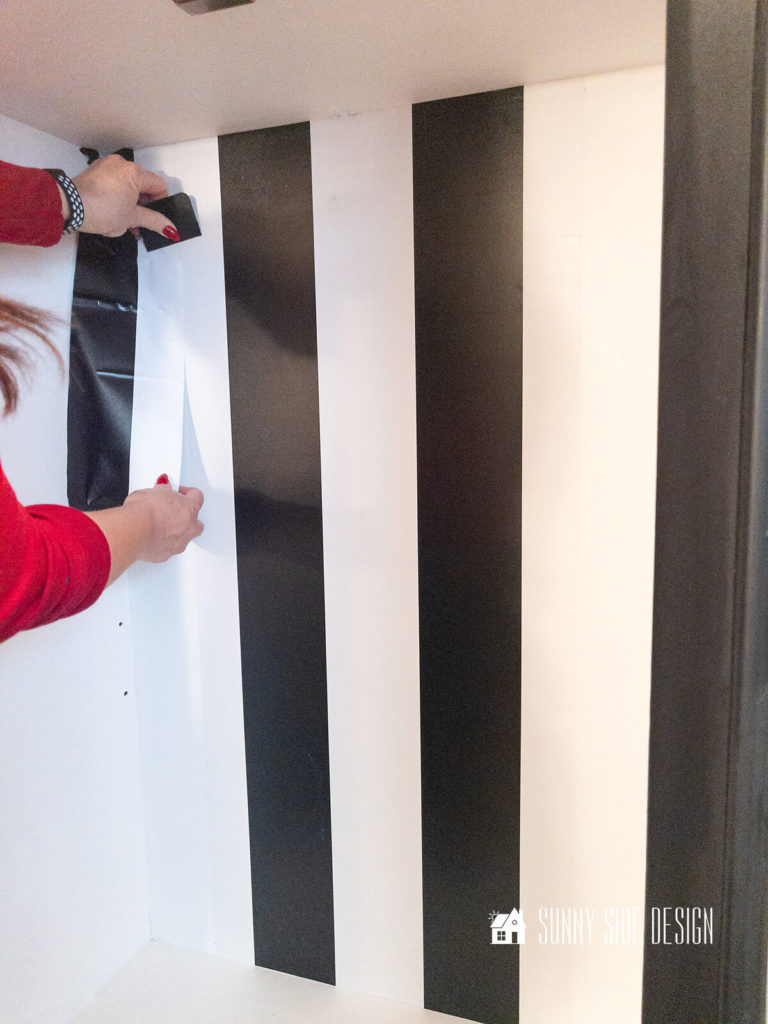 Wallpaper is placed to the back of the hutch top, with painters tape with the pattern centered