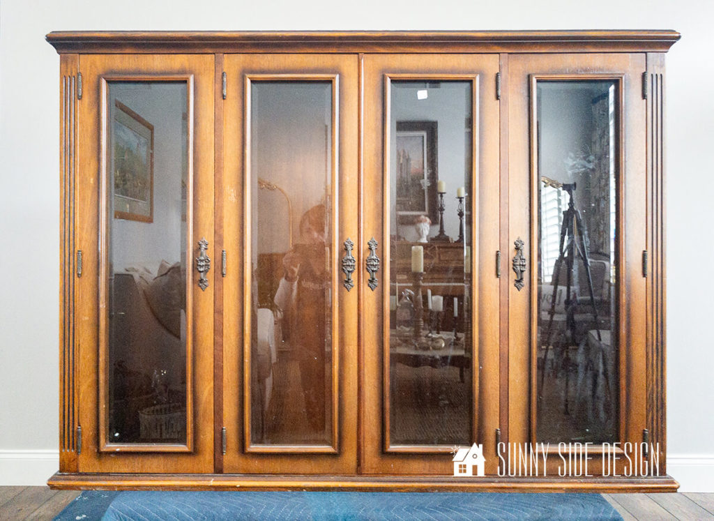 $5 thrifted hutch top before makeover, glass doors with a stained wood finish.