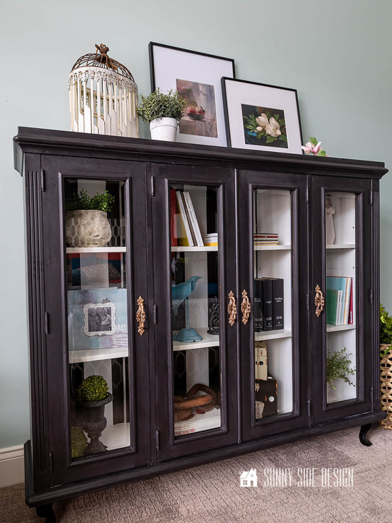 French-inspired bookshelves with glass doors made from a repurposed hutch top. Styled with books, plants and art.
