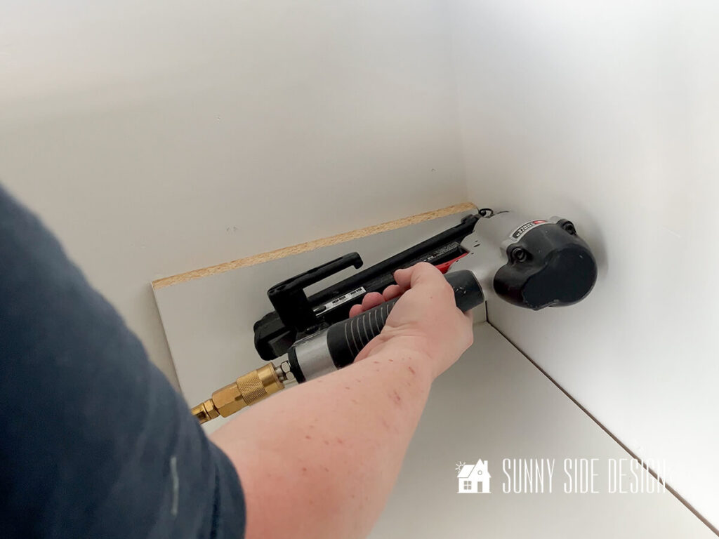 Secure DIY closet organizer to studs in wall with brad nailer.