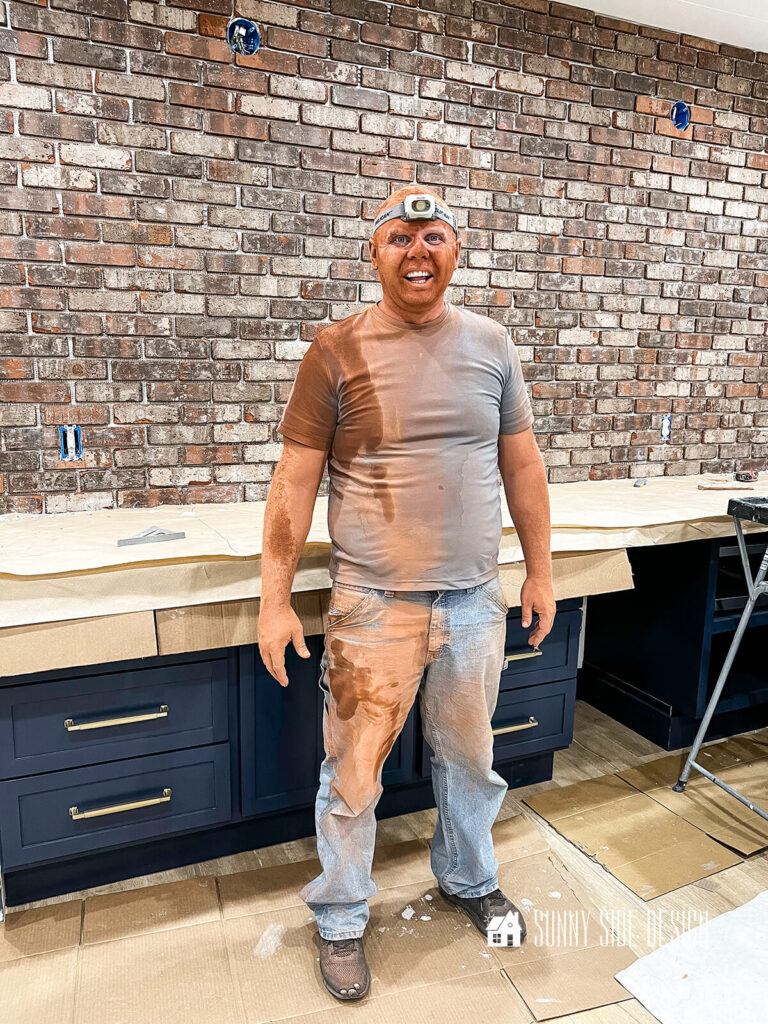 Man covered in overspray from the tile saw.