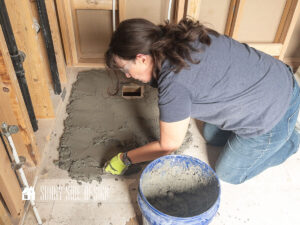 Feature image, Mortar is applied to the subfloor to prepare to install a prefab shower pan in this bathroom remodel.