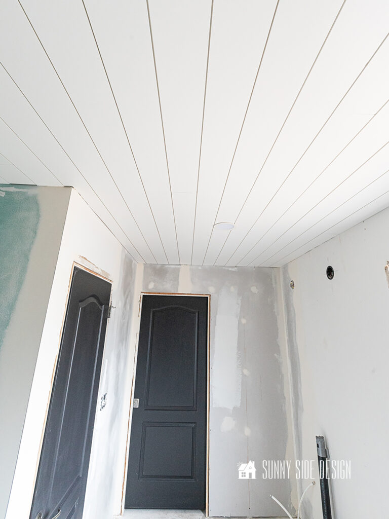 Shiplap bathroom ceiling painted white, walls mudded and ready for primer and paint.