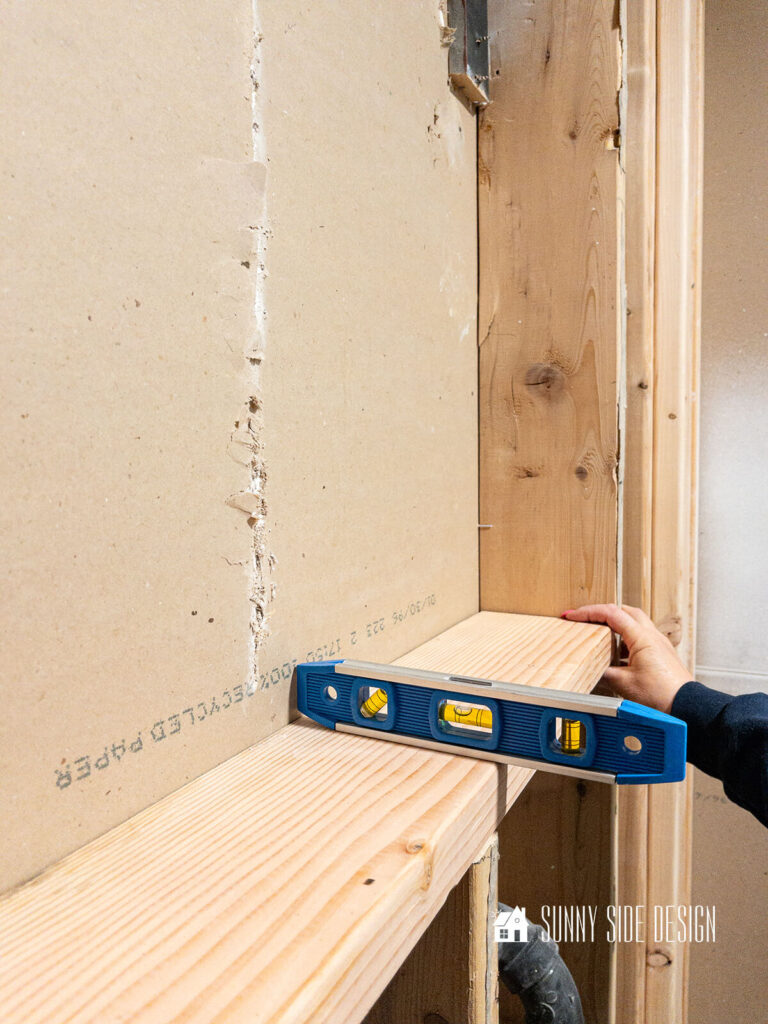 Level is placed on lower shelf. The shelf should slop forward slightly.