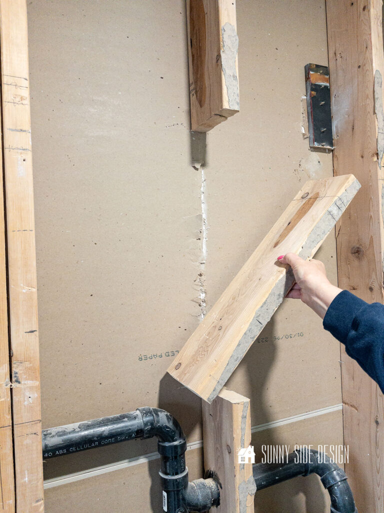A section of the 2x6 wall is removed to allow for a larger niche in the shower.