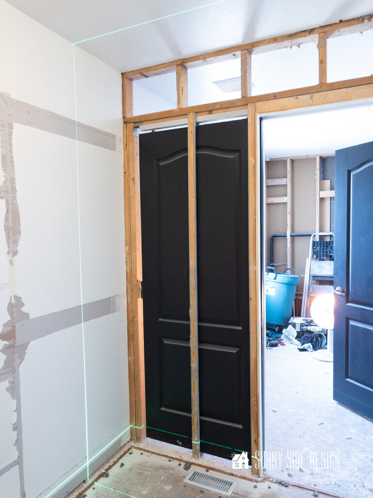 A laser level is used mark the drywall in the walk in closet area. This area of the drywall is to be removed to move back the wall between the bathroom and the walk-in closet.