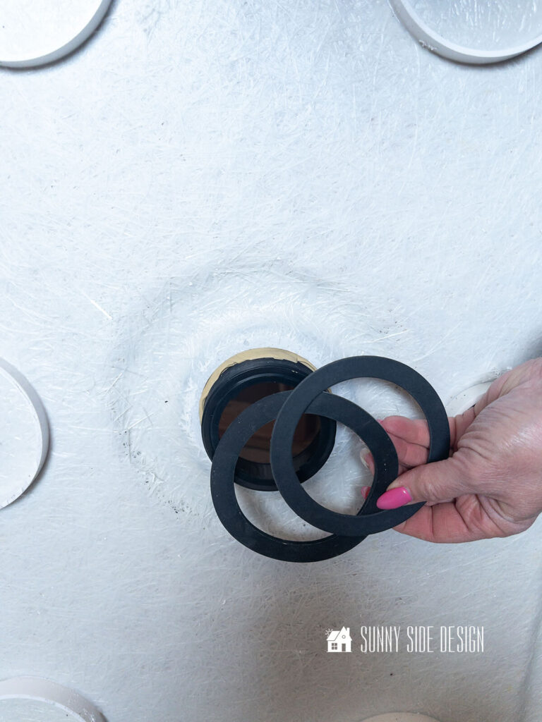 After the top drain piece is placed in the shower pan, the rubber and paper gasket are placed on the drain assembly.